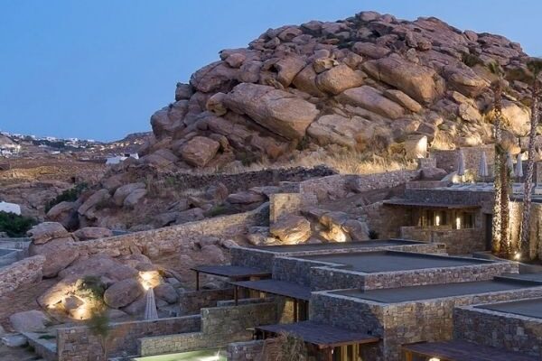 Maximus Mykonos suites set into the rocky hillside at dusk