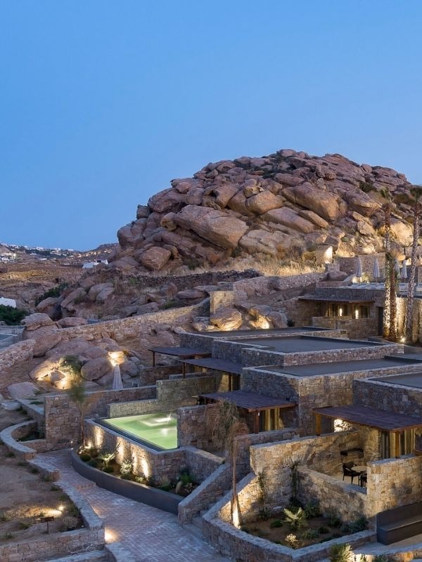 Maximus Mykonos suites set into the rocky hillside at dusk